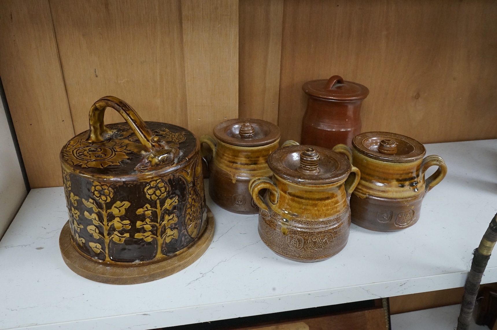 William Lloyd for Sheen Pottery; a slipwear cheese dome, together with three lidded pots by Anthony Morris and another by Colin Thorburn, largest 18cm high (5)